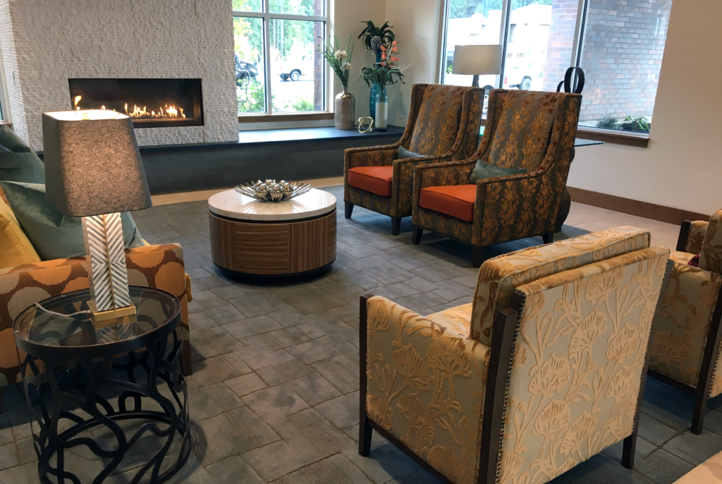Senior Living lobby showcasing high-back lounge chairs with colorful fabrics, and tables made by John Ralph.